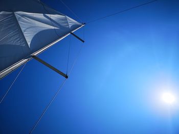 Low angle view of sailboat against blue sky