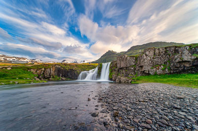 Scenic view of waterfall against sky