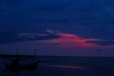 Silhouette boats moored on sea against sky at sunset