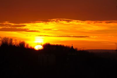 Scenic view of silhouette trees against orange sky