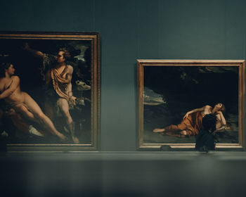 Woman with arms outstretched in museum