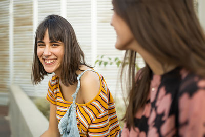 Two beautiful young women sitting laughing