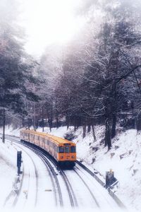 Snow covered railroad tracks with subway in the middle