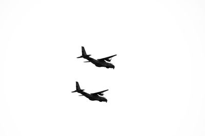 Low angle view of silhouette airplane against clear sky