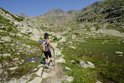 Woman walking on rocks against mountains