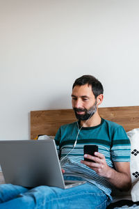 Young man using mobile phone at home