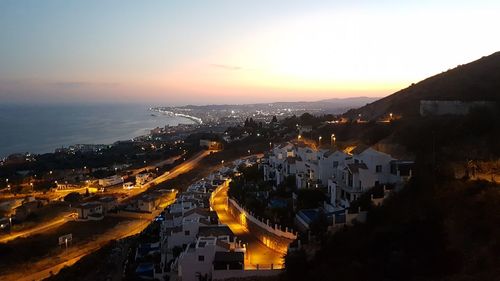 High angle view of illuminated buildings against sky at sunset