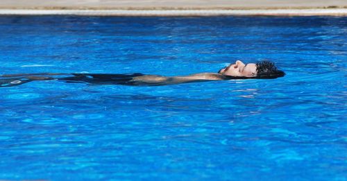 Portrait of man lying in swimming pool