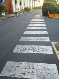 Close-up of zebra crossing on road in city