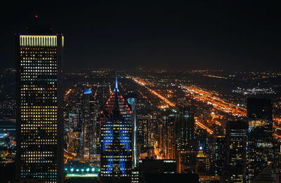 Illuminated buildings in city against sky at night