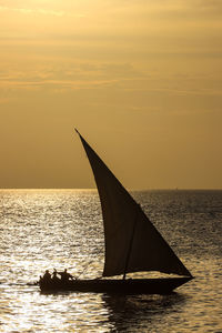 Silhouette sailboat on sea against sky during sunset