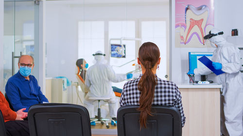 Rear view of female friends working in office