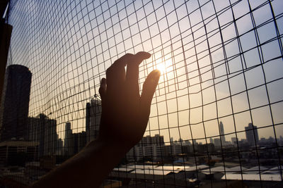 Hand against sky during sunset