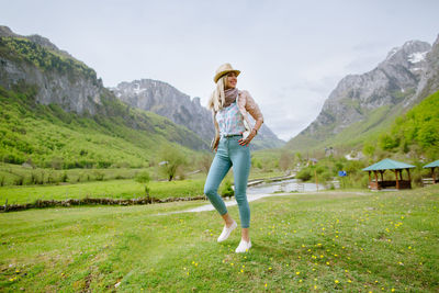 Full length of woman standing on field against sky