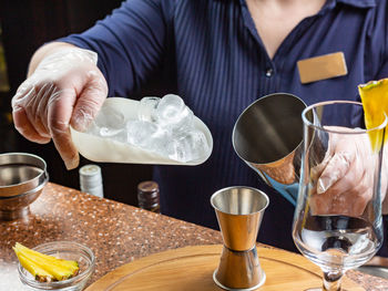 Midsection of man holding wine glass on table