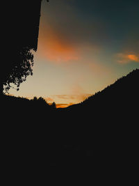 Scenic view of silhouette landscape against orange sky