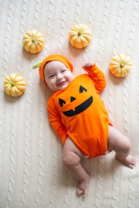 High angle view of baby boy by pumpkins