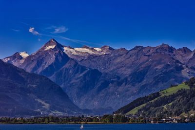 Scenic view of lake and mountains against blue sky