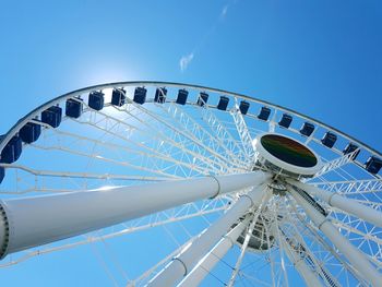 Low angle view of ferris wheel against blue sky