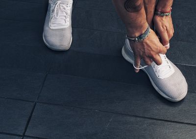 Low section of person sitting on tiled floor