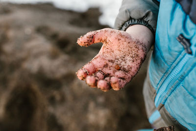 Close-up of messy hand with sand