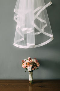 Close-up of flower vase on table against wall at home