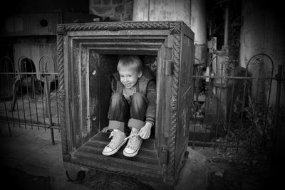 Full length portrait of girl sitting outdoors