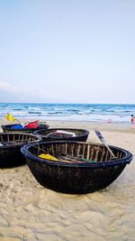 Deck chairs on beach against sky