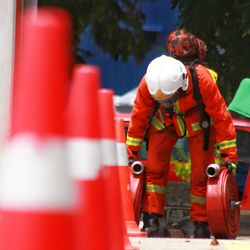 Firefighter with pipes standing by traffic cones