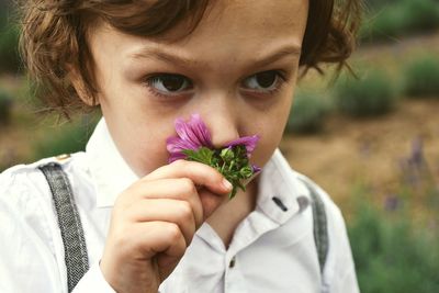 Close-up of boy smelling flower