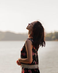 Rear view of young woman standing in sea