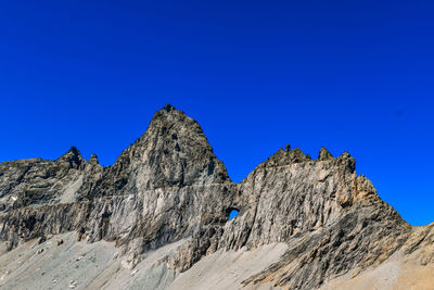 Low angle view of mountain against clear blue sky