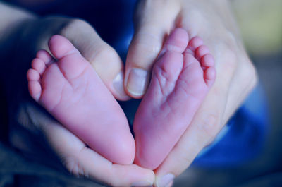 Close-up of father holding baby feet