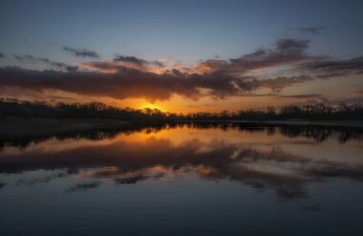 Scenic view of lake against sky during sunset