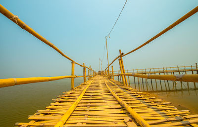 Bridge over calm sea against clear sky