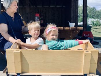 Portrait of happy friends sitting in box