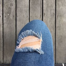 Close-up of woman wearing torn jeans