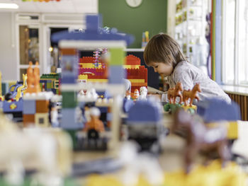 Toddler plays with toy blocks. little boy stares on toy constructor. kindergarten or nursery.