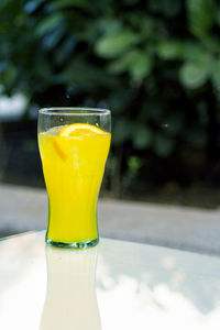 Close-up of yellow glass on table