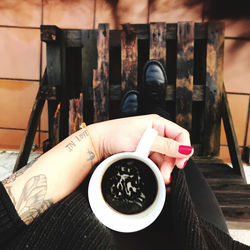 Midsection of woman holding coffee cup