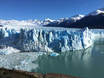Scenic view of glacier in lake against sky
