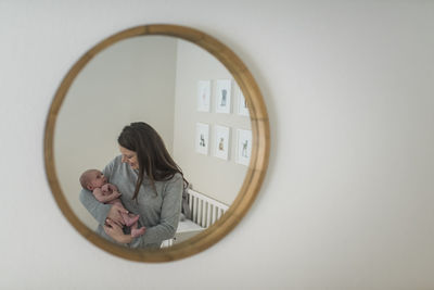 Mother and son reflecting on mirror at home