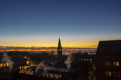 View of illuminated buildings against sky at sunset