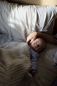 Close-up of baby boy sleeping on bed