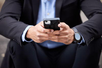 Midsection of man using mobile phone