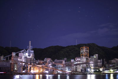 Illuminated city against sky at night