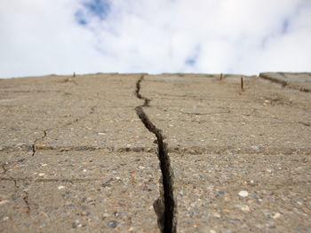 Surface level of barren land against sky