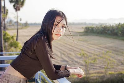 Close up portrait of beautiful cool women standing with rural screen on background.