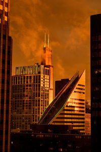 Modern buildings against cloudy sky during sunset