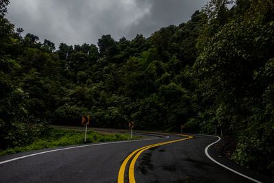 Road amidst trees against sky